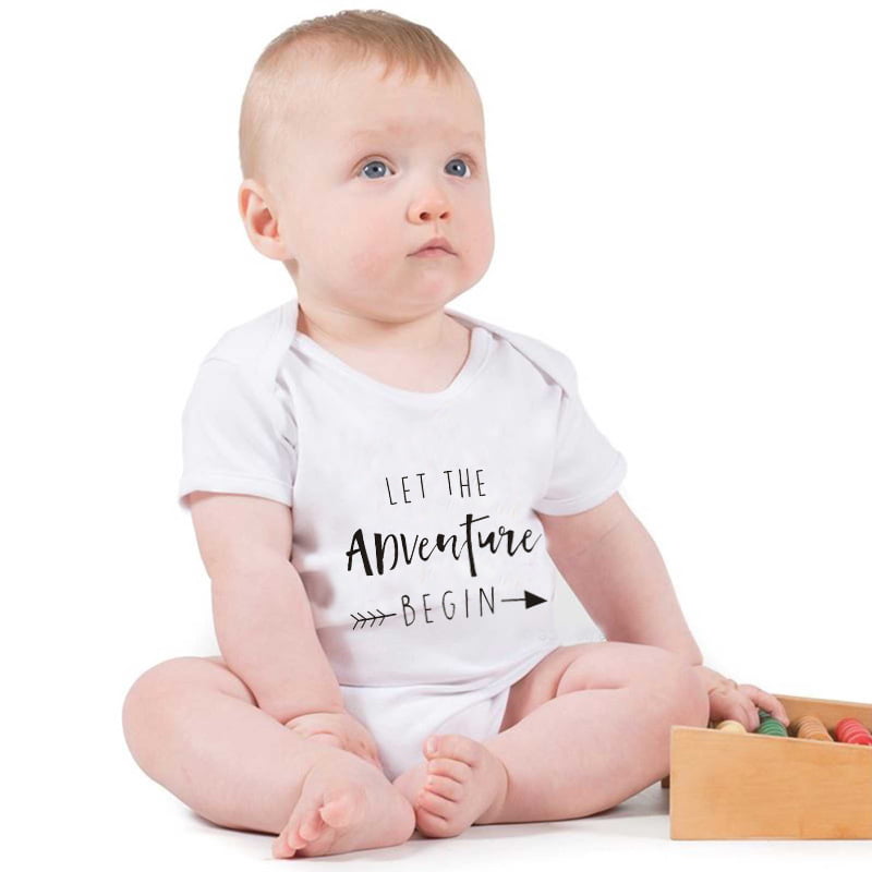 Adorable baby boy in a striped romper playing with toys